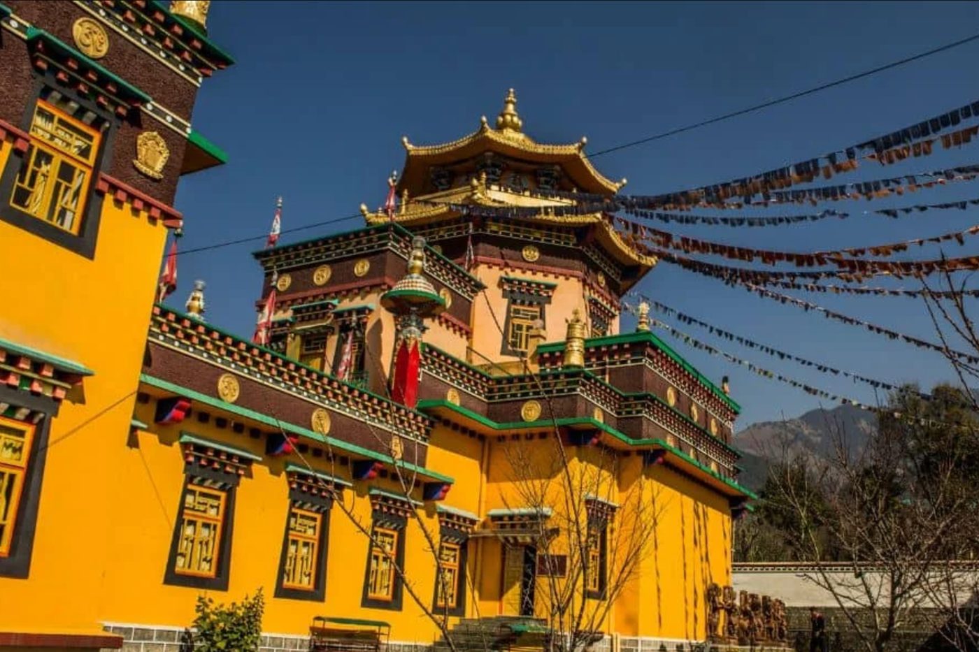A Tibetan monastery with prayer flags against a blue sky