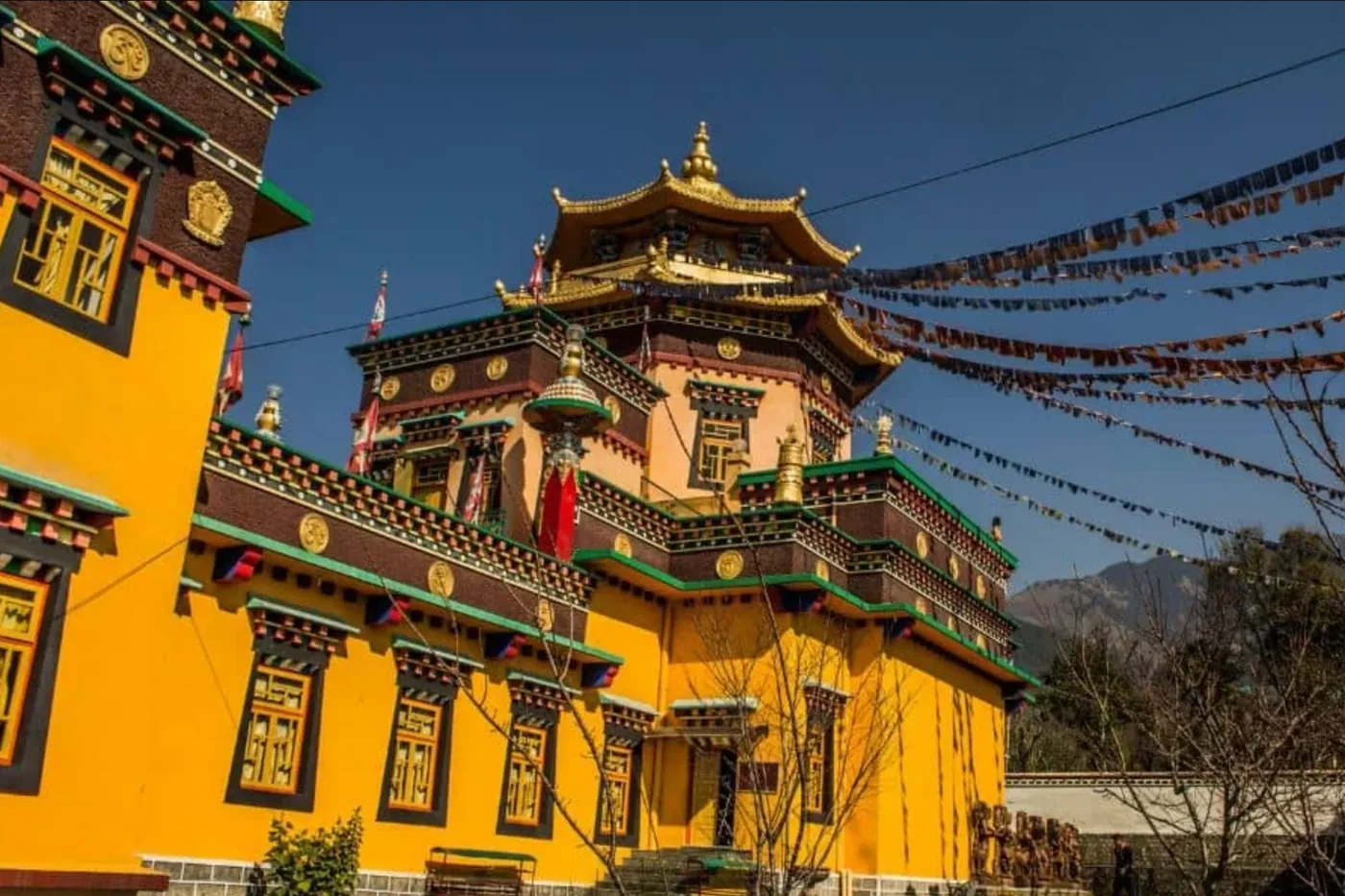 A Tibetan monastery with prayer flags against a blue sky
