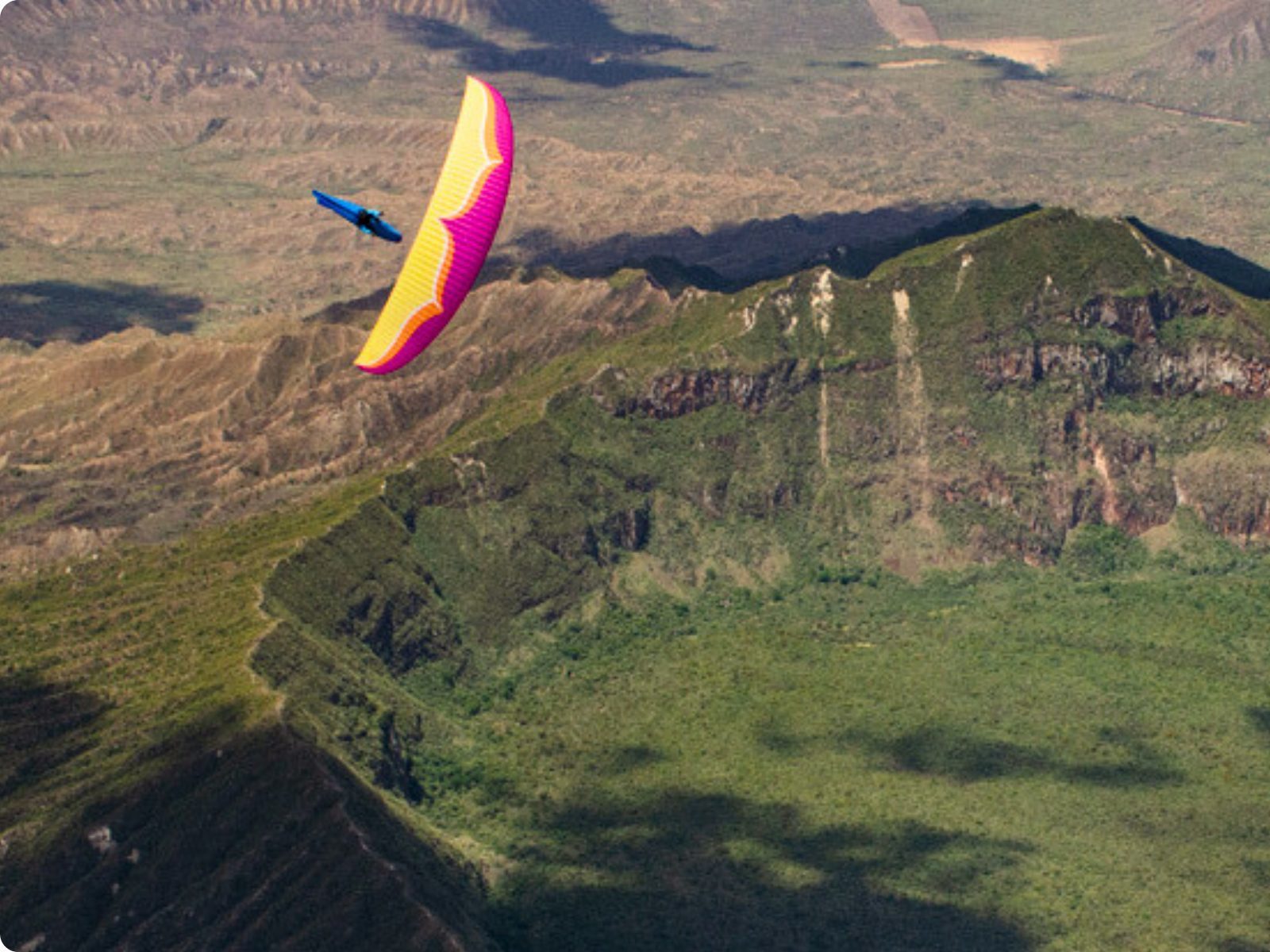 Paraglider over a green Kenyan crater